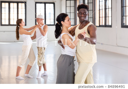 Dancing couples enjoying salsa or bachata 84896491