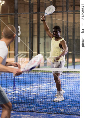 African american paddle tennis player preparing to hit ball on court African american paddle tennis player preparing to hit ball on court 84896631