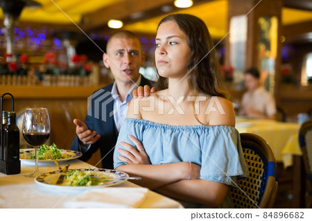 Young couple man and woman quarreling in restaurant Young couple man and woman quarreling in restaurant 84896682