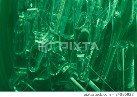 Glass medical ampoule vial for injection. Medicine is liquid sodium chloride with of aqueous solution in ampulla. Close up. Bottles ampule multicolor. 84896928