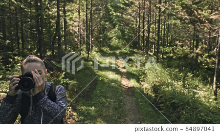 Traveler photographing scenic view in forest. One caucasian woman shooting nice magic look. Girl take photo video on dslr mirrorless camera. Traveler photographing scenic view in forest. One caucasian woman shooting nice magic look. Girl take photo video on dslr mirrorless camera. 84897041
