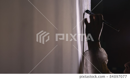 Artist designer draws an eagle on the wall. Craftsman decorator paints picture with acrylic oil color. Painter painter dressed in paint coat. Indoor. 84897077