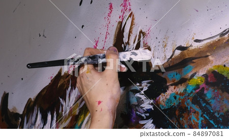 Artist designer draws an eagle on the wall. Craftsman decorator paints a picture with acrylic oil color brush. Close-up dark magic cinematic look. Artist designer draws an eagle on the wall. Craftsman decorator paints a picture with acrylic oil color brush. Close-up dark magic cinematic look. 84897081