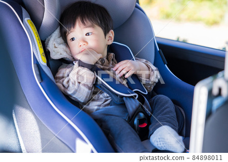 Boy sitting in a child seat Boy sitting in a child seat 84898011