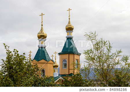 View of a beautiful Orthodox church with gilded domes and crosses. View of a beautiful Orthodox church with gilded domes and crosses. 84898286
