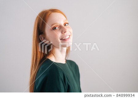 Portrait of cheerful redhead young woman model smiling looking at camera on white background. Portrait of cheerful redhead young woman model smiling looking at camera on white background. 84899934