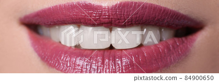 Closeup of woman smile with burgundy lips painted with lipstick 84900650