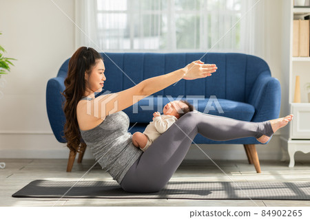Side view of Wellness Asian woman mom doing yoga boat pose or navasana with baby at cozy home.Happy healthy mother yoga exercise newborn baby boy sleep and lying on leg mom.Yoga Mom and Baby Concept Side view of Wellness Asian woman mom doing yoga boat pose or navasana with baby at cozy home.Happy healthy mother yoga exercise newborn baby boy sleep and lying on leg mom.Yoga Mom and Baby Concept 84902265