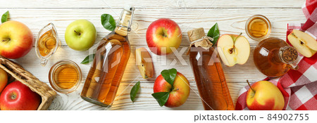 Homemade apple vinegar and ingredients on white wooden table 84902755