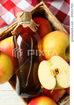 Homemade apple vinegar and ingredients on white wooden table 84902784