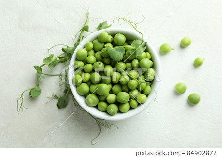 Bowl with pea seeds on white textured background Bowl with pea seeds on white textured background 84902872