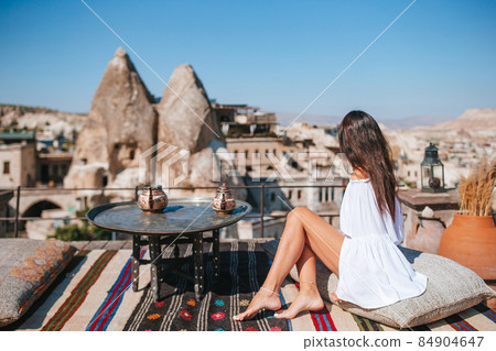 Happy young woman during sunrise watching hot air balloons in Cappadocia, Turkey 84904647