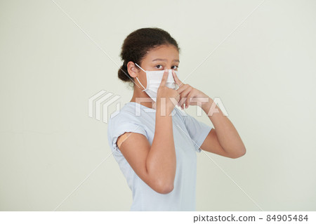 Teenage Girl Putting on Medical Mask Teenage Girl Putting on Medical Mask 84905484