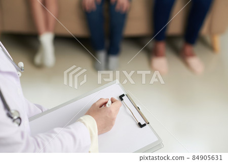 Doctor Filling Form on Clipboard 84905631