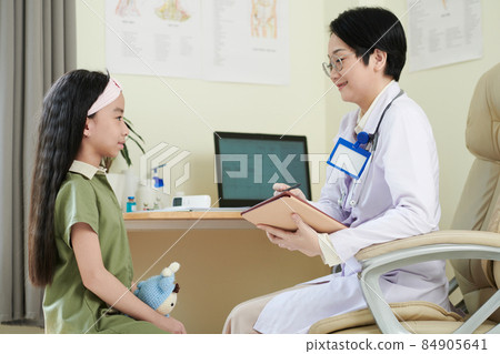 Pediatrician Writing down Complaints of Girl Pediatrician Writing down Complaints of Girl 84905641