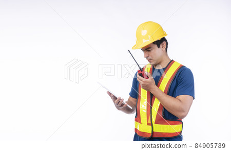 Handsome confident craftsman wear yellow helmet hard hat safety talking with walkie talkie Handsome confident craftsman wear yellow helmet hard hat safety talking with walkie talkie 84905789