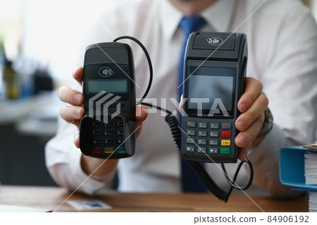 Man hold different models of credit card reader machines for cashless pay 84906192