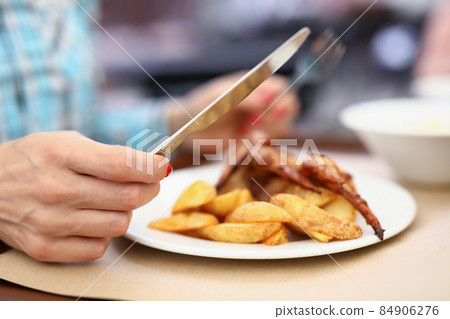 Person having breakfast or lunch in cafe or restaurant, hold knife and fork 84906276