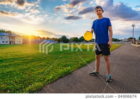 teen boy playing with a ball at a stadium, a soccer field with green grass - sports and health concept teen boy playing with a ball at a stadium, a soccer field with green grass - sports and health concept 84906674