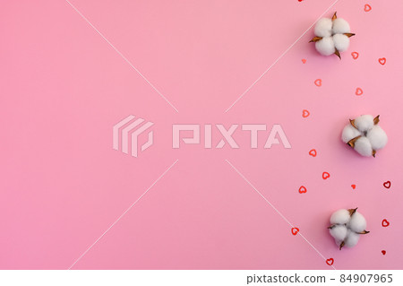 White cotton flowers on a pink background. Little shiny hearts. copy space White cotton flowers on a pink background. Little shiny hearts. copy space 84907965
