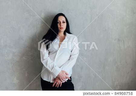 portrait of a beautiful fashionable brunette woman in a white shirt portrait of a beautiful fashionable brunette woman in a white shirt 84908758