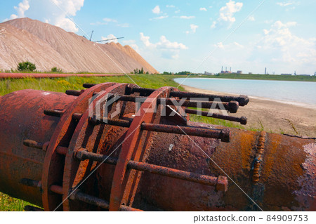 Large old production pipe in production. Background of industry. Extraction of salt, fertilizers. Large old production pipe in production. Background of industry. Extraction of salt, fertilizers. 84909753