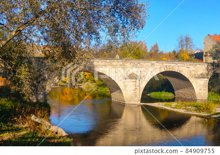 Beautiful old bridge over the river on a sunny day. Beautiful old bridge over the river on a sunny day. 84909755