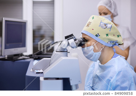 The surgeon uses a microscope during surgery 84909858