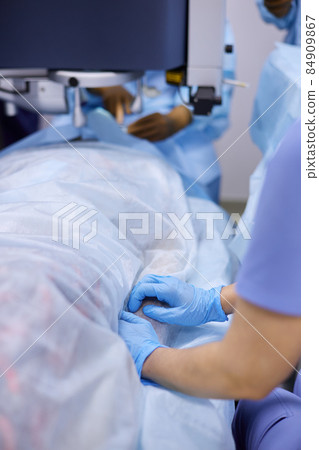 Surgeons performing eye surgery in the operating room 84909867