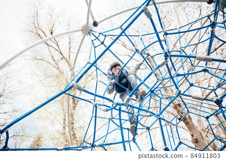 beautiful little boy playing in a rope maze 84911803