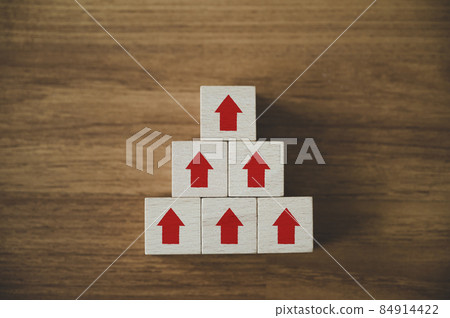 Business growth success concept. Wooden cube block with arrow on top pyramid Business growth success concept. Wooden cube block with arrow on top pyramid 84914422
