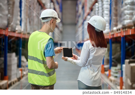 Woman showing tablet to worker with back to camera Woman showing tablet to worker with back to camera 84914834