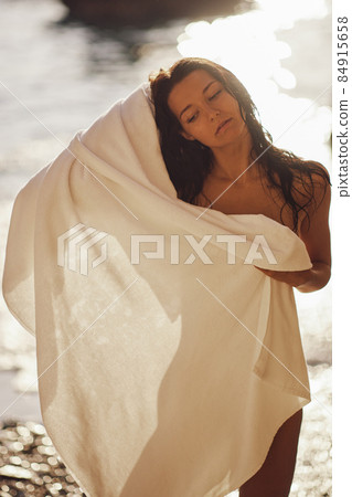 Adorable Beach Woman in the Towel Drying after Swimming on the Deserted Beach During Summer Vacation Outdoors Adorable Beach Woman in the Towel Drying after Swimming on the Deserted Beach During Summer Vacation Outdoors 84915658