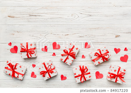 Valentine day composition: red gift box with bow and heart. Christmas present. View from above. Space for text. Holday greeting card Valentine day composition: red gift box with bow and heart. Christmas present. View from above. Space for text. Holday greeting card 84917220