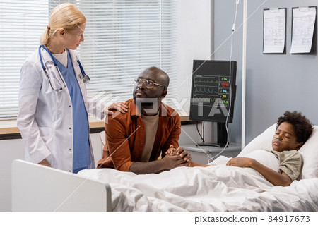 Doctor talking to parent at hospital ward Doctor talking to parent at hospital ward 84917673