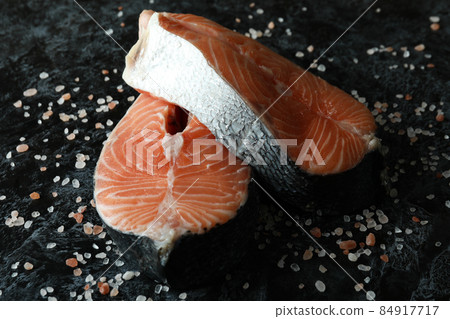 Fresh raw salmon and salt on black smokey background 84917717