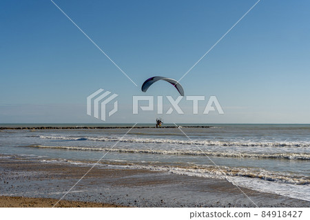 View of a paraglider crossing the beautiful Burriana beach in Spain. You need to do this sport to release the adrenaline and relieve stress 84918427