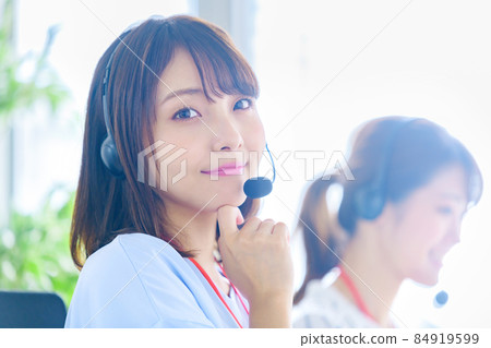 A young female operator looking at a camera working in a call center A young female operator looking at a camera working in a call center 84919599