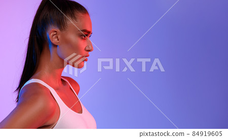 Profile Portrait Of Sporty Lady Posing Looking Aside, Neon Background Profile Portrait Of Sporty Lady Posing Looking Aside, Neon Background 84919605