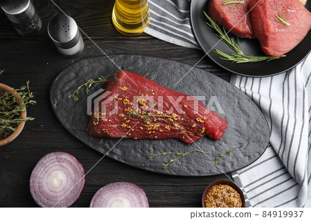 Flat lay composition with fresh beef cut on black wooden table Flat lay composition with fresh beef cut on black wooden table 84919937