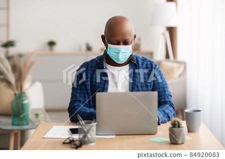 Mature Black Man Using Laptop Wearing Face Mask In Office Mature Black Man Using Laptop Wearing Face Mask In Office 84920083