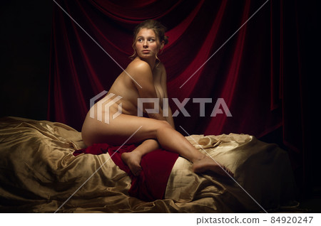 Vintage portrait of young medieval beautiful girl posing like artist's model on dark background. Renaissance style concept 84920247