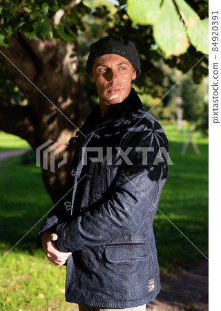 Adult handsome man in a coat and cap. Adult handsome man in a coat and cap. 84920391