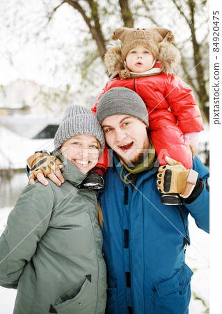 Portrait of happy family with one kid in winter casual outfit Portrait of happy family with one kid in winter casual outfit 84920475
