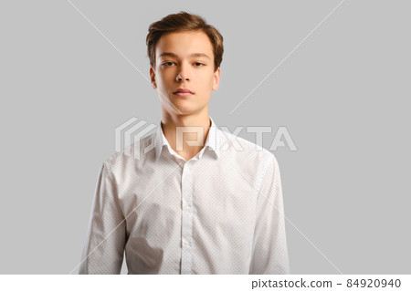 Portrait of handsome young man in white shirt over grey background 84920940
