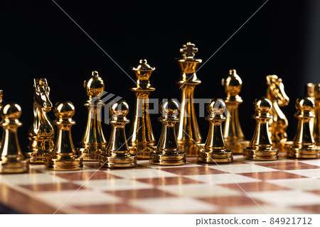 Golden chess figures standing on chessboard 84921712