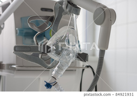 Non-invasive ventilation face mask, on background medical ventilator in ICU in hospital. 84921931