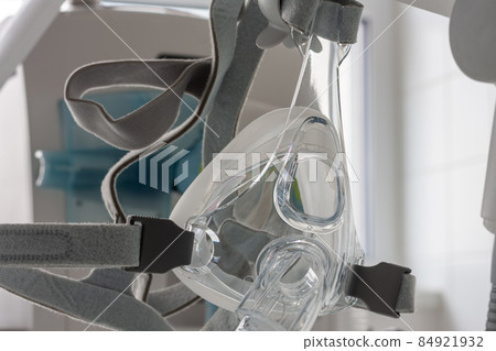 Non-invasive ventilation face mask, on background medical ventilator in ICU in hospital. 84921932