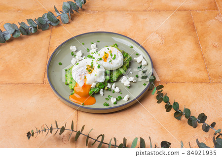 Green peas with poached eggs on sand color background 84921935