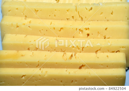 Pieces of juicy cheese cut on a cutting board 84922504